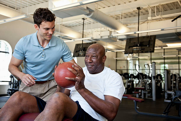 hombre trabajando con pelota de ejercicio - indoors occupational therapy physical therapy healthcare and medicine fotografías e imágenes de stock