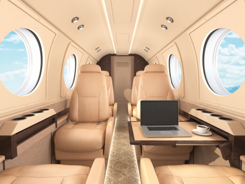 Interior of a business / private jet with laptop.