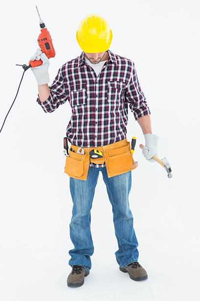 istock Male repairman holding drill machine and hammer 468673424