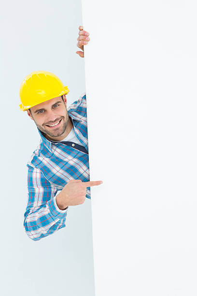istock Confident repairman pointing at blank billboard 468676536