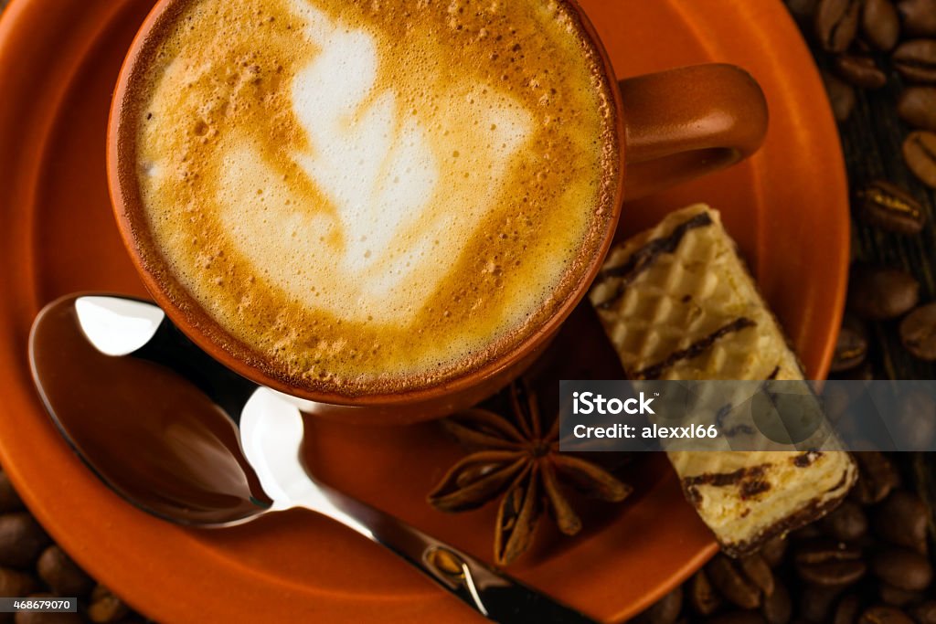 cup of cappuccino, milk-chocolate wafer and coffee beans ceramic cup of cappuccino, milk-chocolate wafer and coffee beans on wooden background 2015 Stock Photo