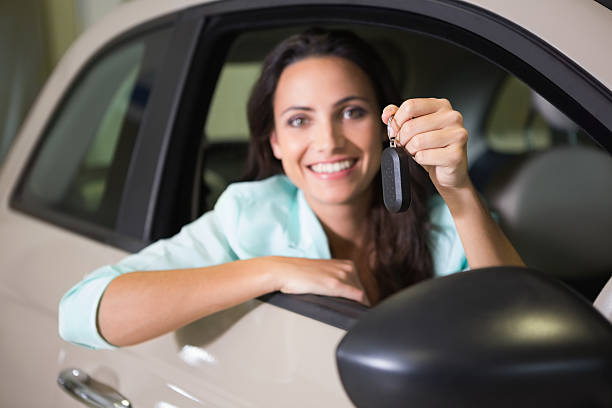 istock Smiling woman holding car key 468680228