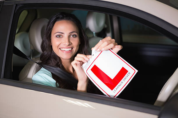 istock Cheerful female driver tearing up her L sign 468680284