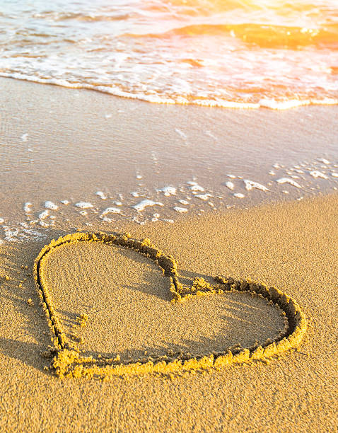 istock Heart drawn in sea beach sand, soft wave. 468680424