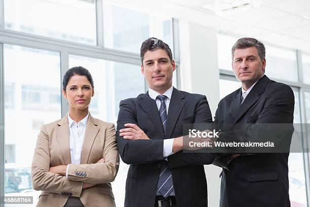 Serious Business Team Standing With Arms Crossed Stock Photo - Download Image Now - 2015, 30-39 Years, 35-39 Years