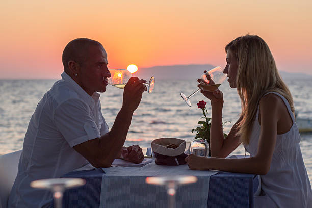 Couple drinking wine at sunset stock photo