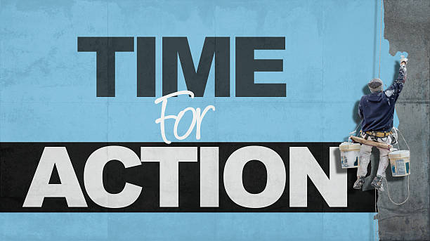 Time for action Painter hanging from harness painting a wall with the words time for action just do it stock pictures, royalty-free photos & images