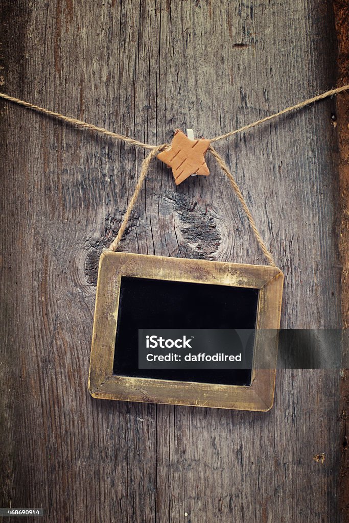 Empty blackboard Empty blackboard with christmas decorations on rope on aged wooden table. Place for text. 2015 Stock Photo