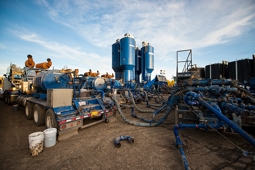 Dawson Creek, Canada - October 10, 2014: Hydraulic fracturing or fracking site and equipment. Fracking is gaining popularity as a technique to access liquified natural gas, but has raised questions of environmental side effects, including the incursion of fracking fluids and released gas into nearby ground water.