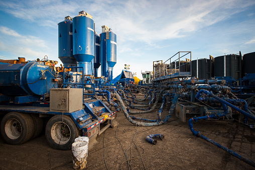 Dawson Creek, Canada - October 10, 2014: Hydraulic fracturing or fracking site and equipment. Fracking is gaining popularity as a technique to access liquified natural gas, but has raised questions of environmental side effects, including the incursion of fracking fluids and released gas into nearby ground water.