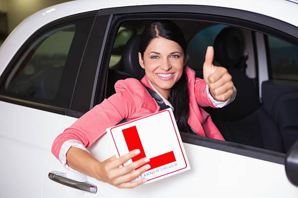 istock Woman gesturing thumbs up holding a learner driver sign 468708520