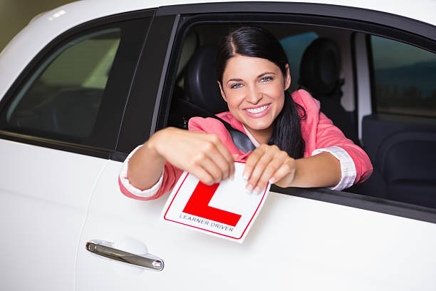 istock Cheerful female driver tearing up her L sign 468708578