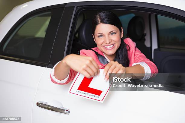Cheerful Female Driver Tearing Up Her L Sign Stock Photo - Download Image Now - 2015, 80-89 Years, Active Seniors