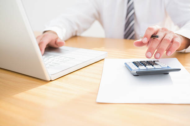 istock A businessman at his desk using a computer and calculator  468709974