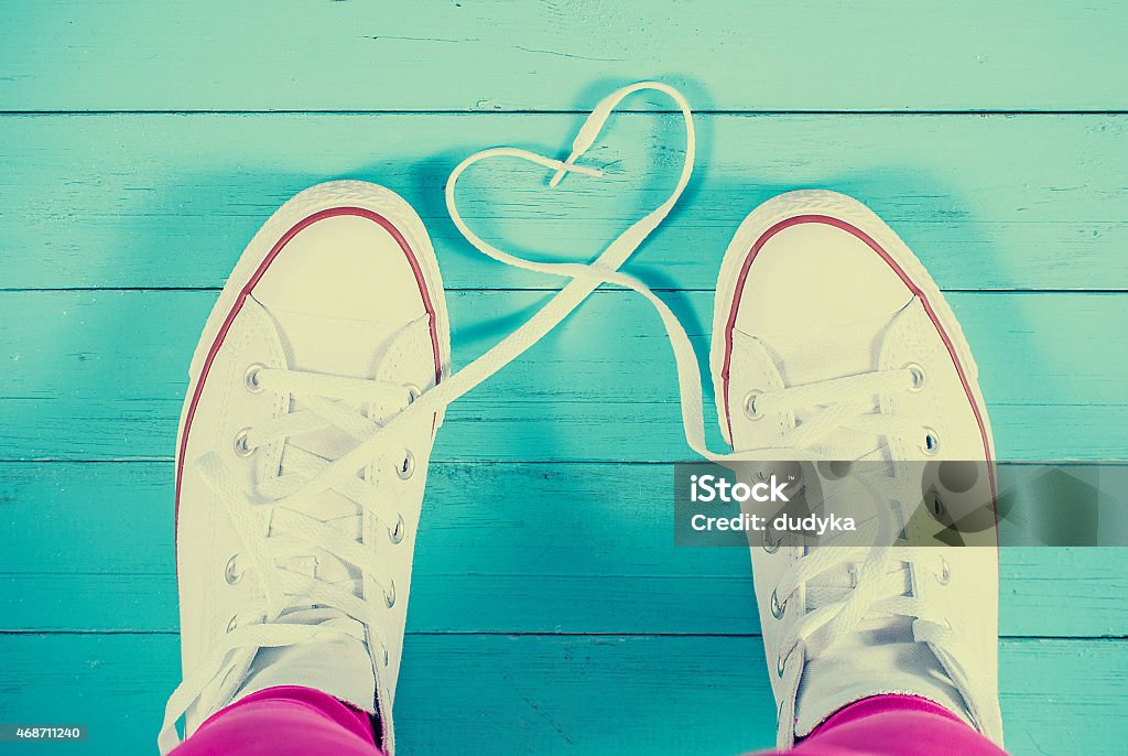 Sneakers with heart on blue wood background, filtered image White sneakers with heart on blue wood background, filtered image 2015 Stock Photo