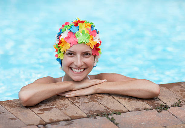 mitte erwachsene frau mit bunten swimcap im swimmingpool - bademütze stock-fotos und bilder