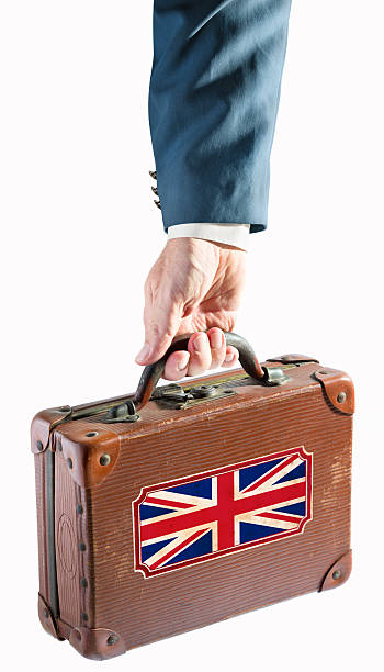 istock Businessman holding antique suitcase Great Britain flag 468719721