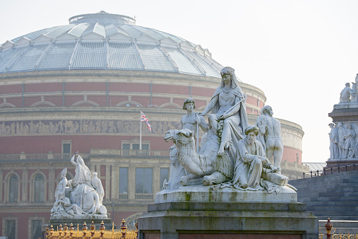 Albert Memorial statue overlooking hazy Royal Albert Hall, in London. The concert hall is home to the Proms, which take place each summer since 1941.