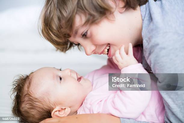 Baby Girl Laughing To Her Brother Stock Photo - Download Image Now - Affectionate, Baby - Human Age, Baby Girls