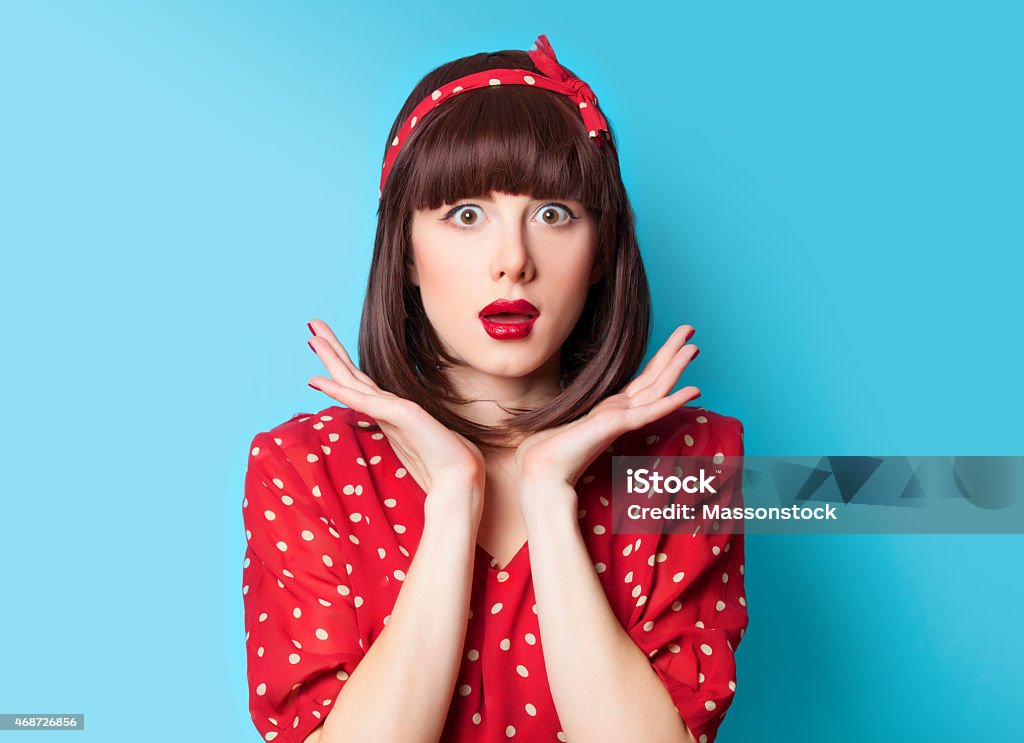 brunette girl in red dress on blue background Portrait of a beautiful brunette girl in red dress on blue background. 2015 Stock Photo