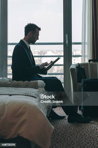 Businessman Sitting In Hotel Room And Using Digital Tablet Stock Photo - Download Image Now