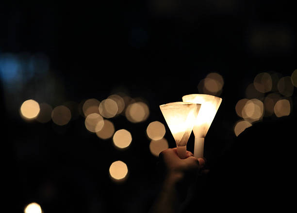 finding the light in dark. a haza candlelight vigil find each other in darkness, blur background in hong kong victoria park