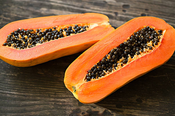 istock Sliced fresh papaya on wooden background 468731738