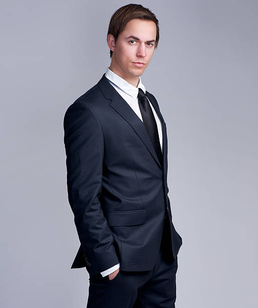 istock Handsome young businessman standing against gray background 468731869