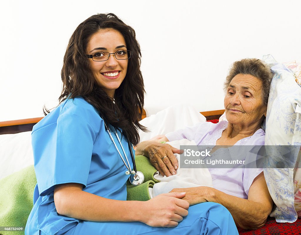 Nurse Caring for Elder Patients Smiling nurse caring for kind elder patient in nursing home. Adult Stock Photo