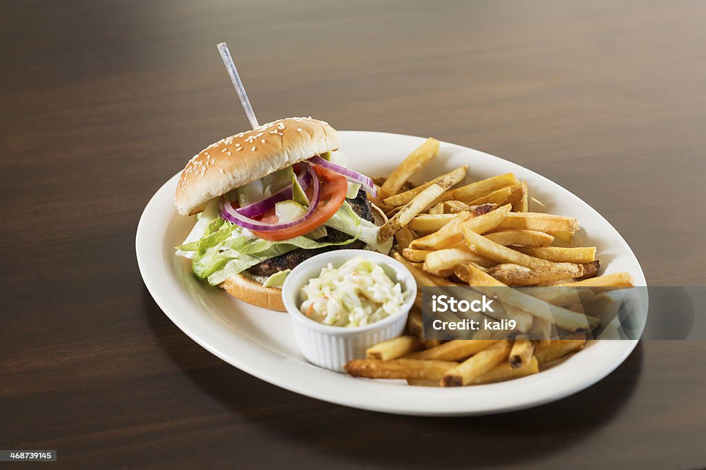 Unhealthy lunch Unhealthy lunch: Hamburger, french fries and cole slaw.  Shallow depth of field. Bun - Bread Stock Photo