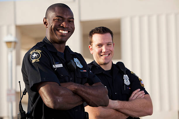 Police officers Multi-ethnic police officers (20s).  Focus on African American man. police force stock pictures, royalty-free photos & images