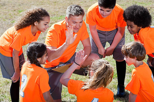 entrenador con equipo de deportes para niños - soccer child coach childhood fotografías e imágenes de stock