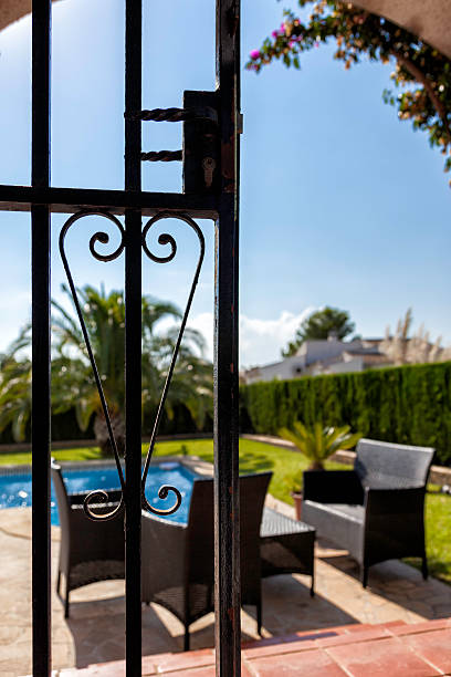 Behind bars Perspective from the terrace of a summer house from the gate playing with the background blur. pool gate stock pictures, royalty-free photos & images