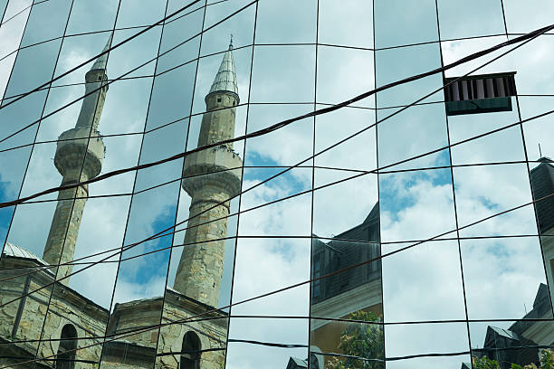 istock Mosque reflected in modern glass office building 468741005