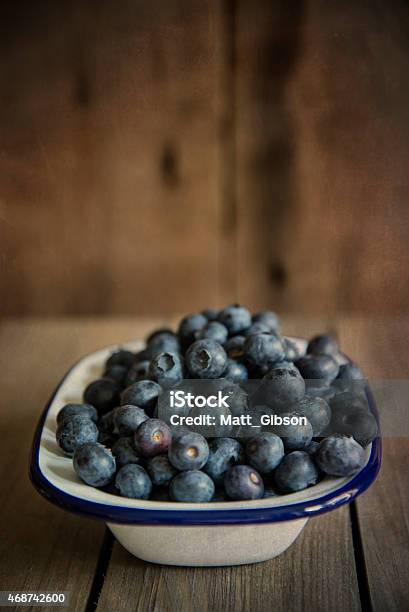 Blueberries In Rustic Kitchen Setting With Old Wooden Background Stock Photo - Download Image Now