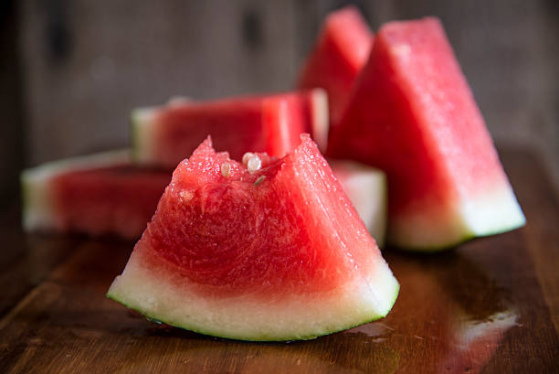 istock Sliced juicy watermelon on wooden chopping board 468742604