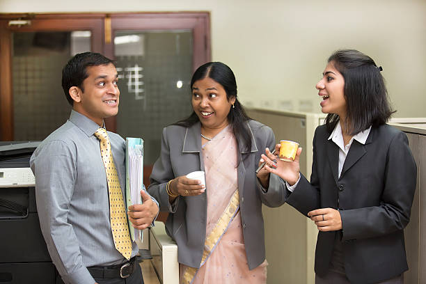 Printer Gossip: Indian business people chatting by the printer.