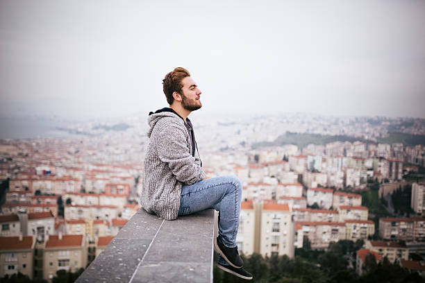 istock Young man sitting with cityscape 468747262