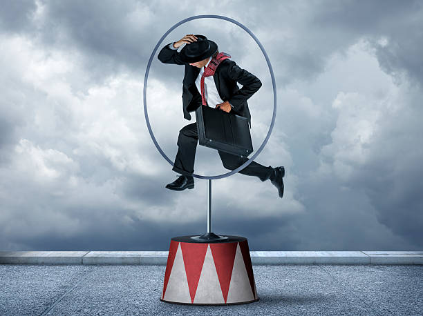 istock Businessman Jumping Through Hoops 468747412