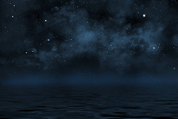 Photo of night sky with stars and blue nebula over water