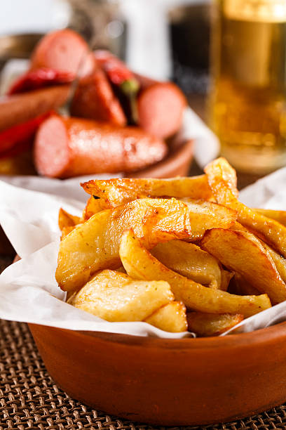 istock Fried Potatoes on old wooden cutting board with bowl ketchup. 468762610