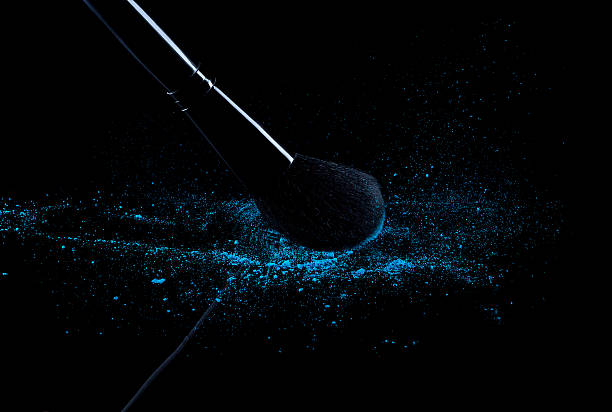 istock Blue powder with beauty brush isolated on black 468774980