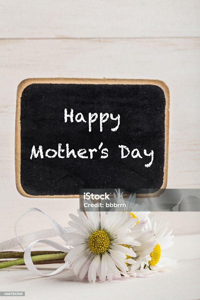 mother's day greeting mother's day greeting with blackboard and daisies on wooden surface 2015 Stock Photo