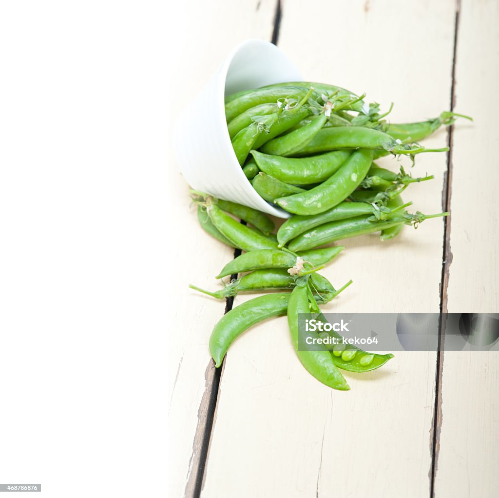 hearthy fresh green peas hearthy fresh green peas  over a rustic wood table 2015 Stock Photo