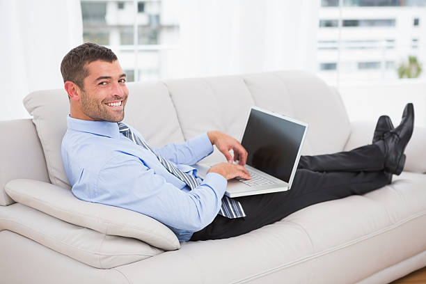 istock Relaxing businessman on sofa with a laptop 468791624