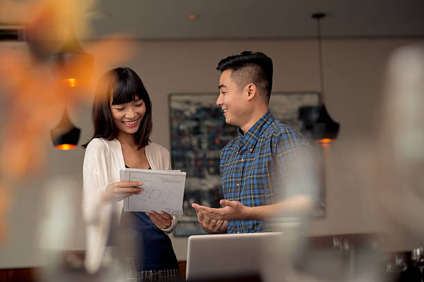 istock 2 people stood up smiling and discussing a business idea 468791802