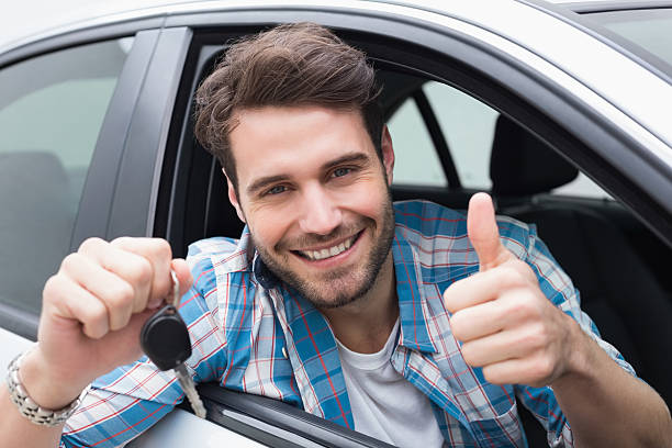 istock Young man smiling at camera showing key 468791932