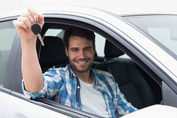 istock Young man smiling and holding key 468791950
