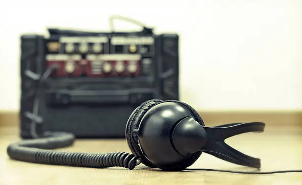 Photo of Headphones and guitar amplifier