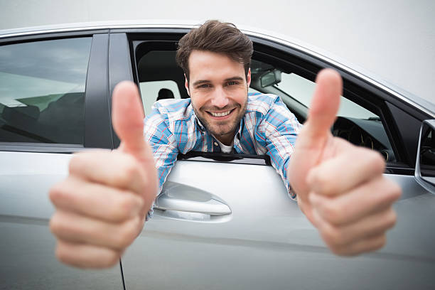 istock Young man smiling at camera showing thumbs up 468794560